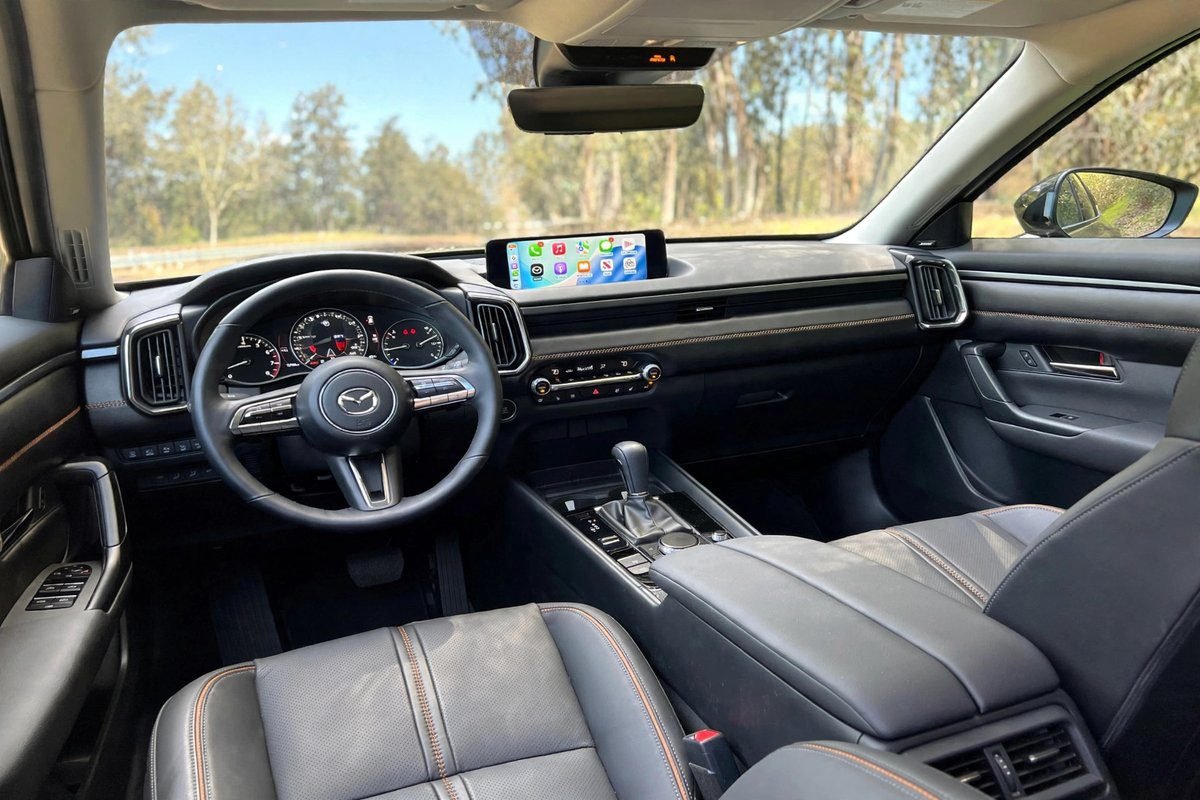 The Mazda CX-50 interior showing the driver-focused dashboard, center touchscreen and leather seats.